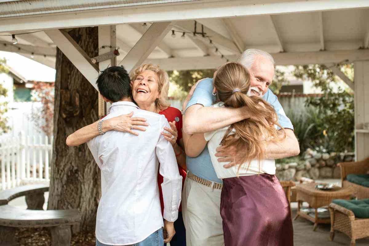 Elderly parents warmly hugging their adult children during a family reunion, symbolizing healing and reconnection after estrangement.