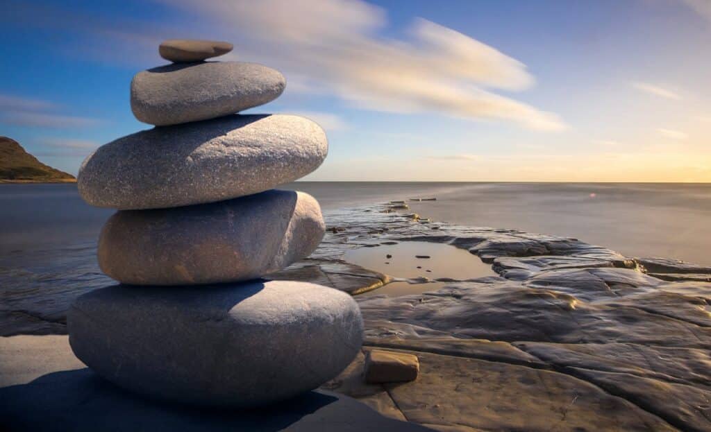 Balanced stones on a rocky shoreline symbolizing emotional balance and healing through Internal Family Systems therapy in Seattle.