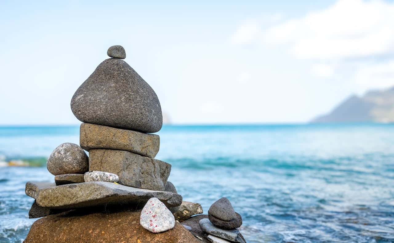 Stacked shoreline stones representing inner harmony and self-leadership in Internal Family Systems (IFS) therapy.