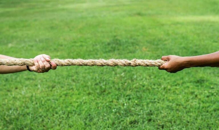 Close-up of a hand pulling a rope during a tug-of-war game.